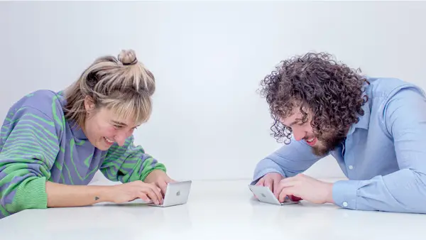 merel and danny sitting behind a super tiny laptop